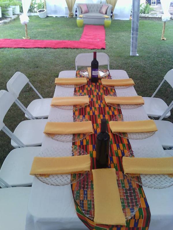 Kente-patterned table runner with gold napkins on a white-clothed table for a traditional engagement